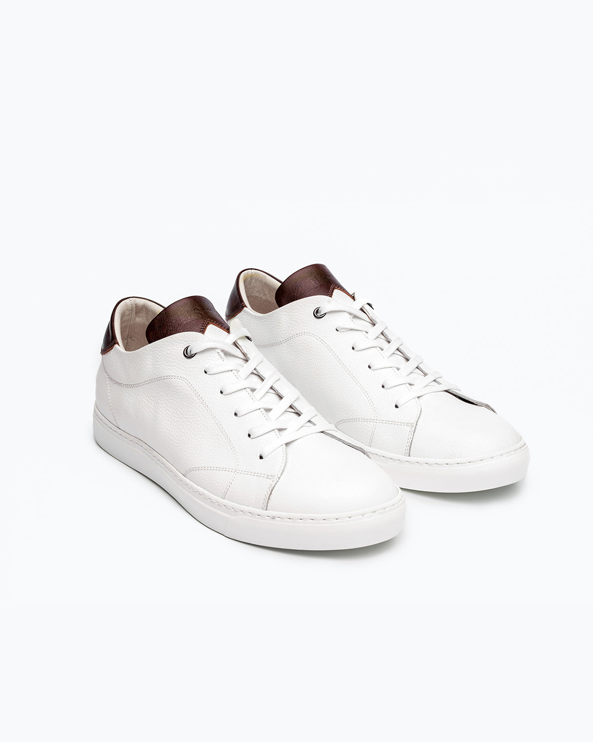 White, brown DLS sneakers, shown in a studio still life.