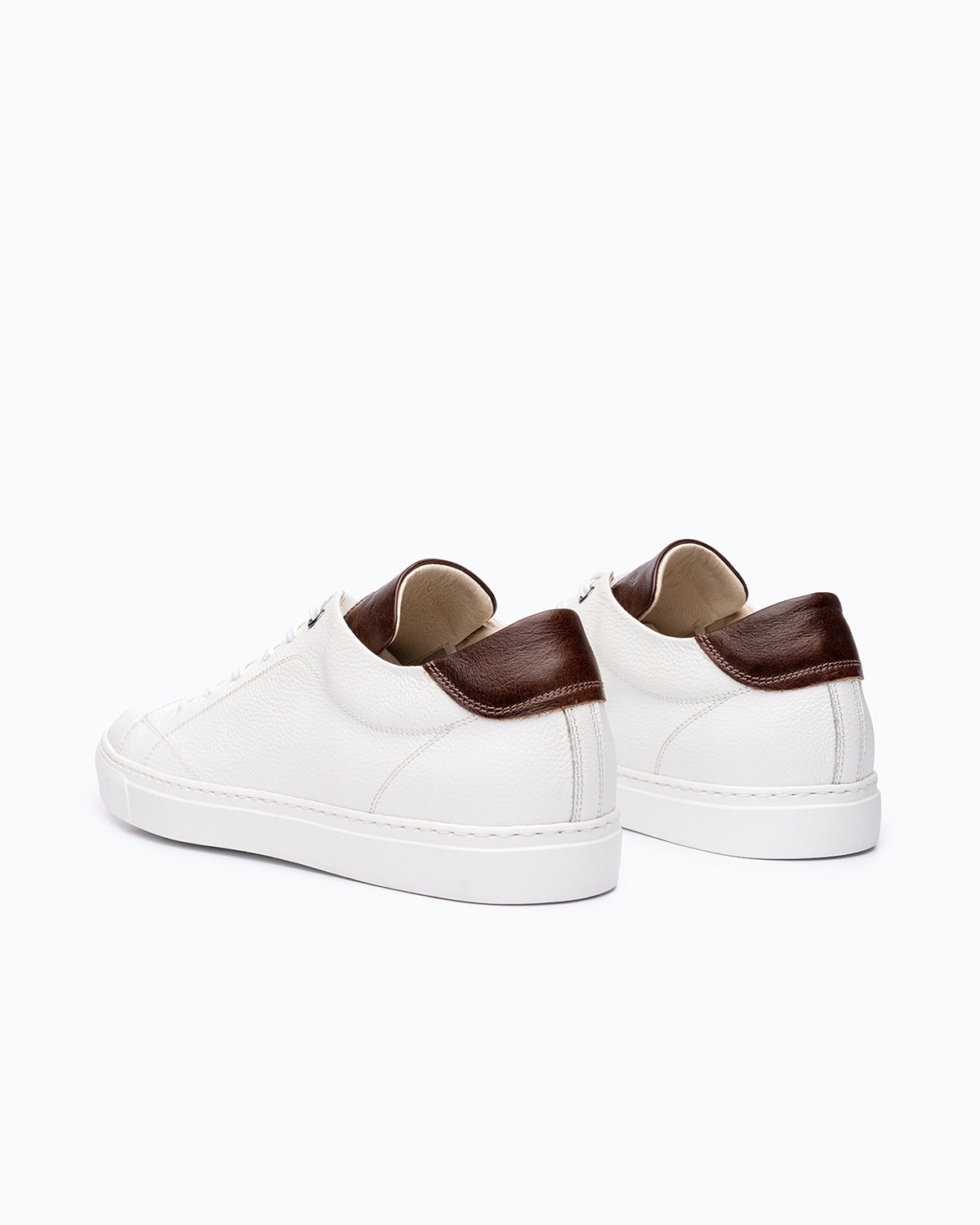 White, brown DLS sneakers, shown in a studio still life.
