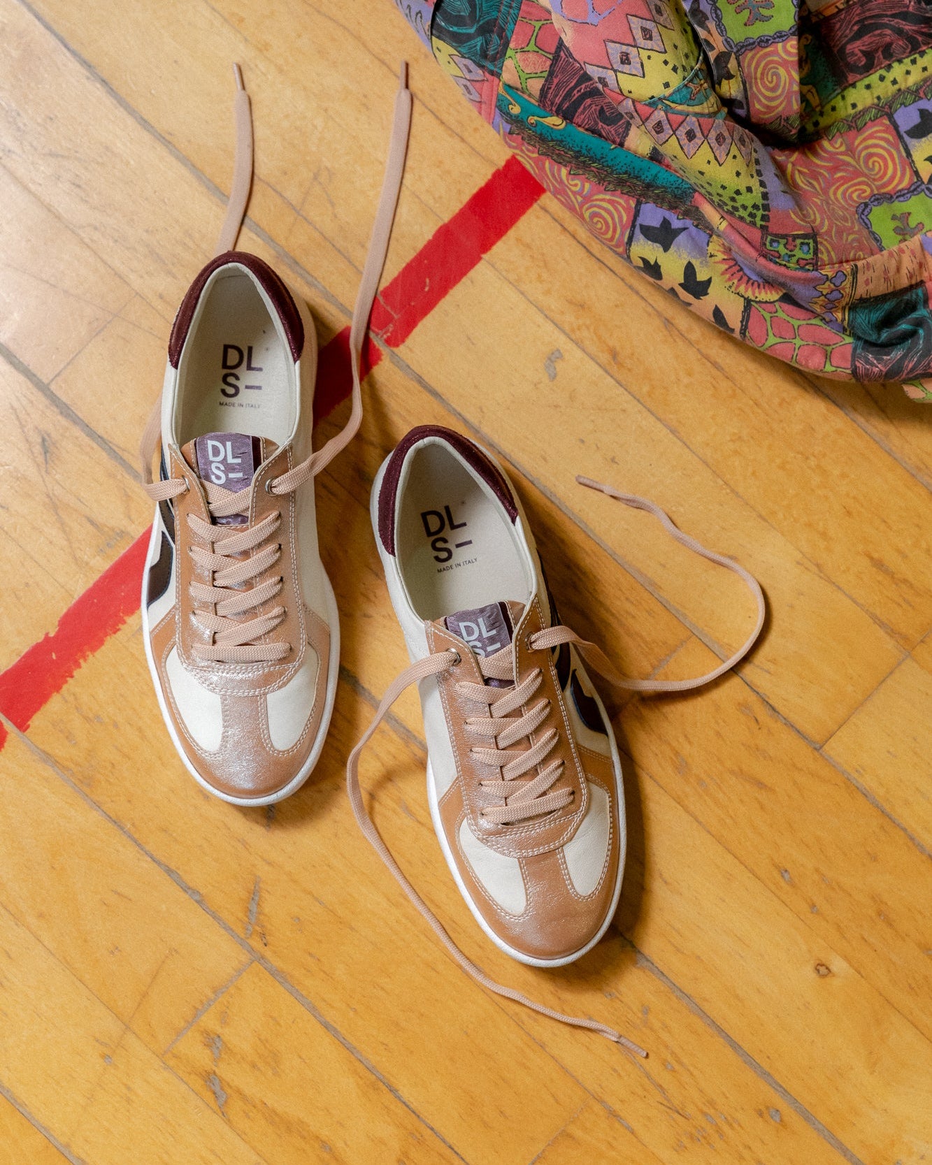 Deep red, ivory, rose nappa leather and glitter Re-Novo trainers, depicted in a casual editorial context.