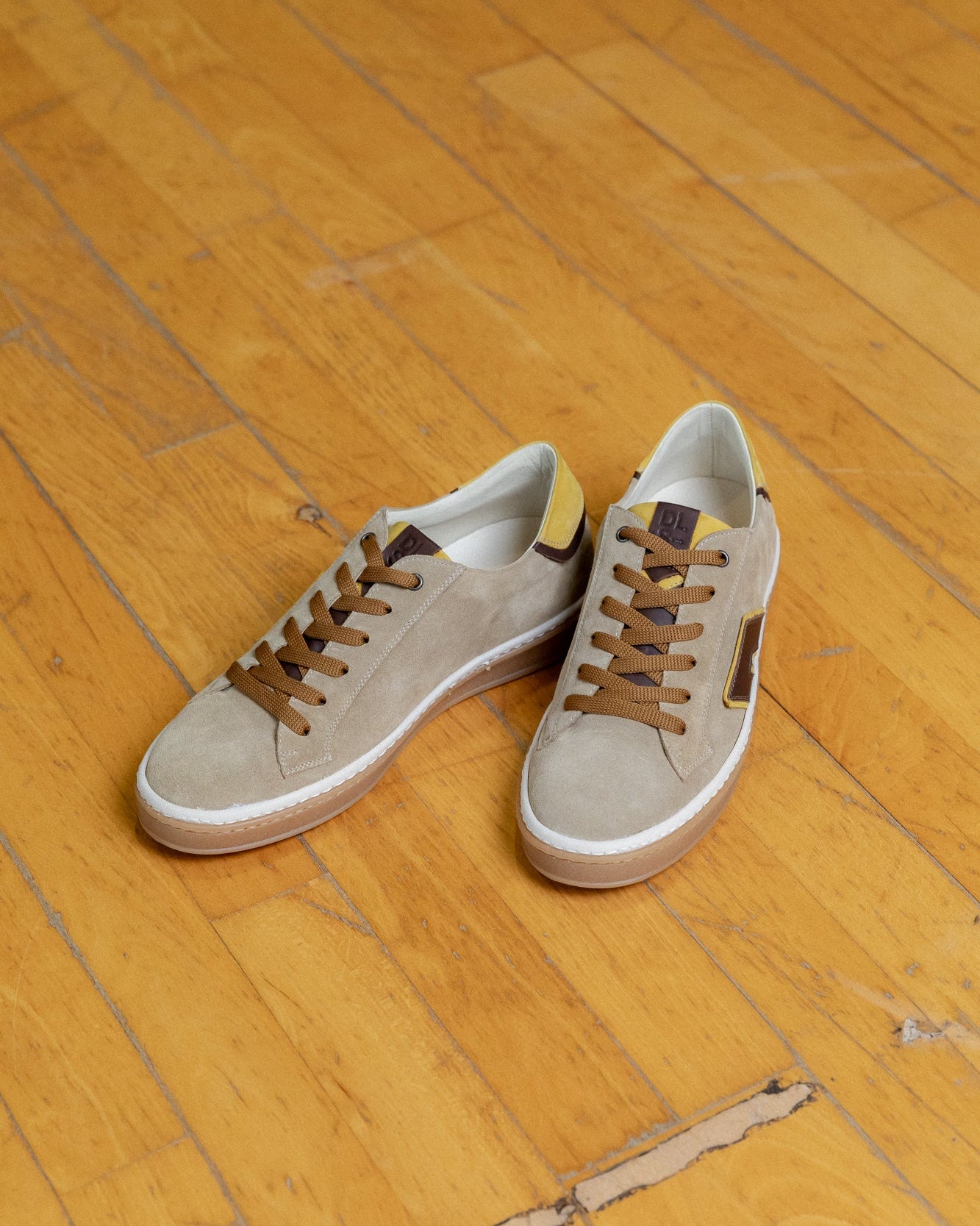Mustard gold, sand, tan velour and nubuck Re-Novo leather sneakers, featured in a styled outdoor setting.