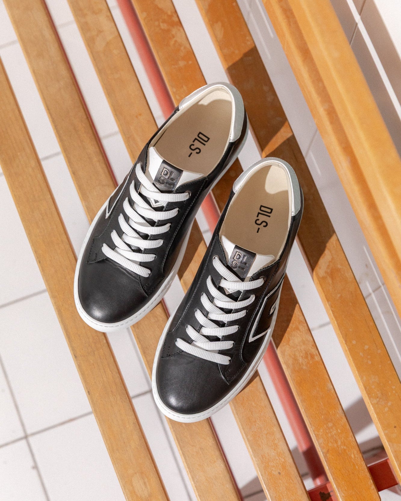 Jet black, off-white Re-Novo trainers, depicted in a casual editorial context.