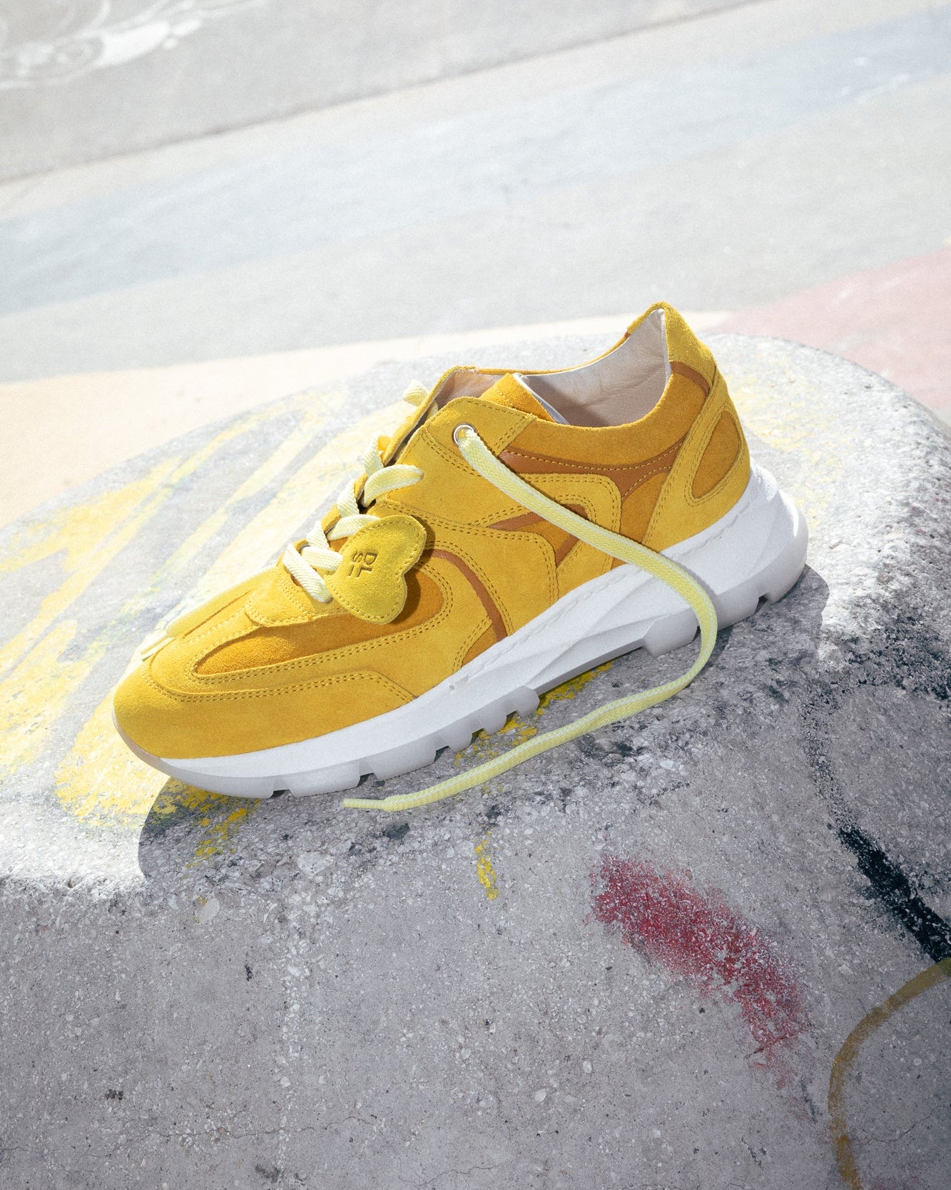 Yellow velour Re-Novo leather sneakers, featured in a styled outdoor setting.