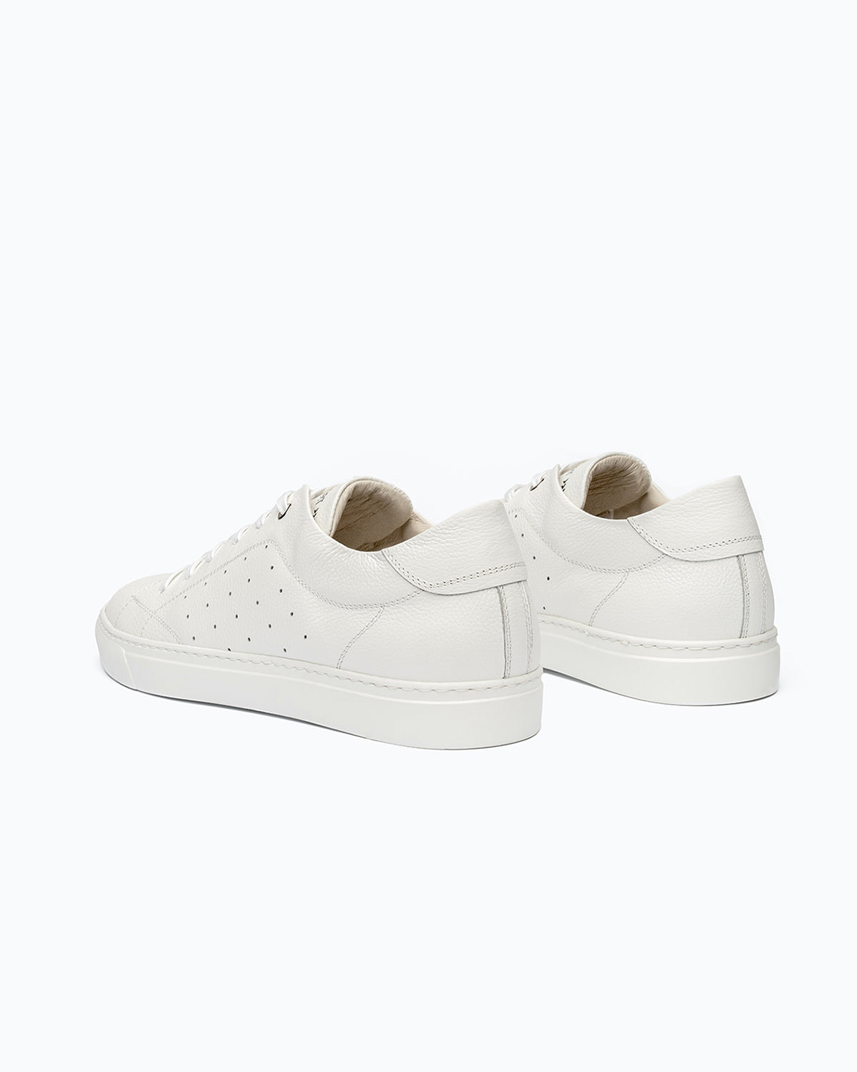 White DLS sneakers, shown in a studio still life.