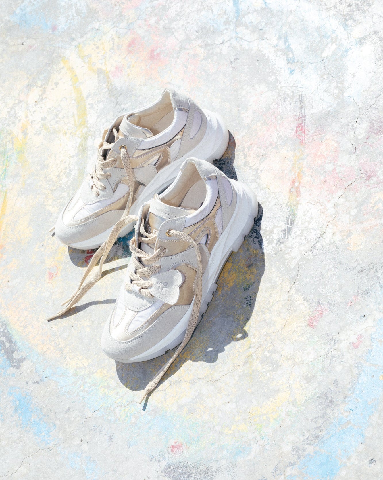 Off-white, ecru velour and satin Re-Novo leather sneakers, photographed on location in a lifestyle scene