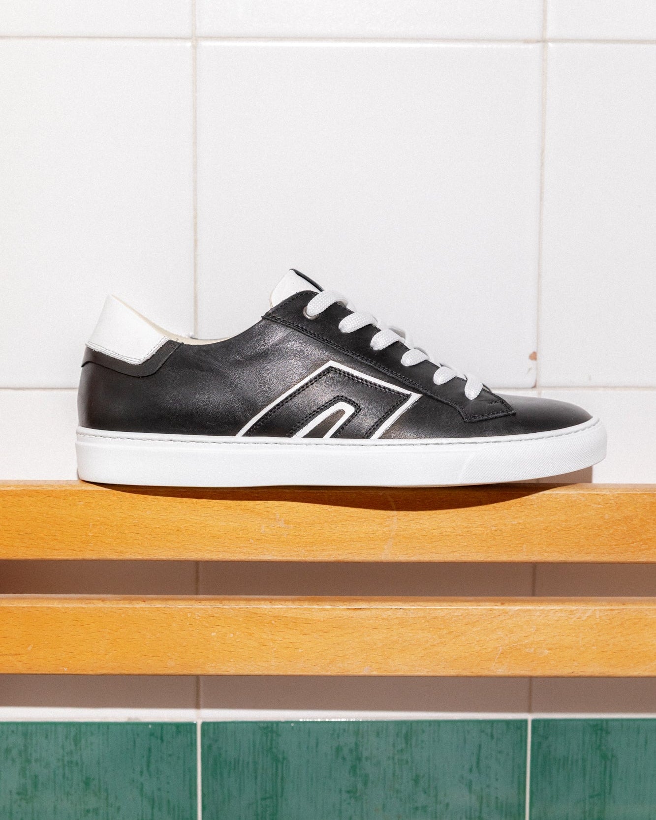 Black, white Re-Novo sneakers, shown in a fashion lifestyle photograph.