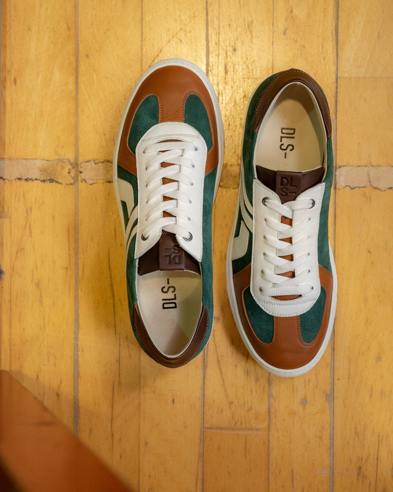 Olive green, tan velour and leather Re-Novo sneakers, photographed in a lifestyle setting.