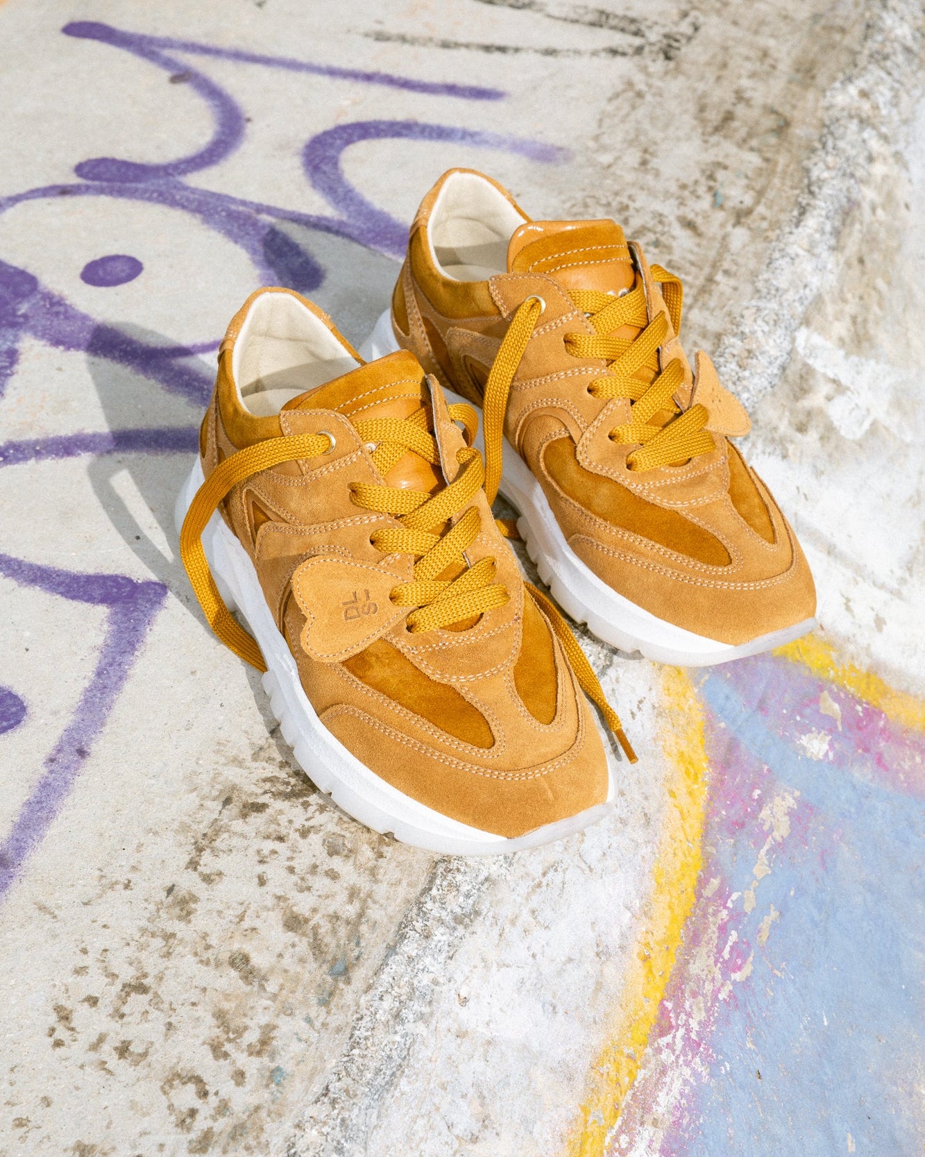 Rust, orange velour Re-Novo fashion sneakers, presented in an on-location lifestyle image.